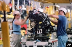 FILE - Workers at a factory in Georgetown, Kentucky.