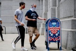 Benjamin Graff, center, and his son Jacob Graff, 19, drop off their mail-in ballots for the Pennsylvania primary election, in Philadelphia, Tuesday, June 2, 2020. (AP Photo/Matt Rourke)