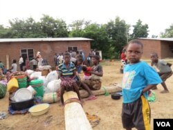 Edess Maison - in striped blouse - says she has left goats, pigs and maize fields behind and disputes her government's assertions that they are running away from hunger. (L. Masina/VOA)
