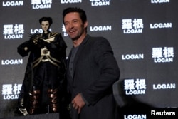 Actor Hugh Jackman poses with a cloth puppet, a traditional type of opera during a news conference during the Asian premiere of the X-Men series film 'Logan' in Taipei, Taiwan, Feb. 28, 2017.