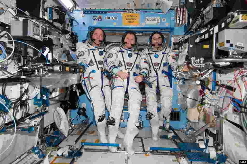 Tiga astronot di Stasiun Antariksa Internasional (ISS) yang segera mengakhiri masa tugasnya di laboratorium antariksa, berpose bersama dalam pakaian astronot mereka. Dari kiri astronot NASA Kevin Ford, dan dua astronot Roscosmos Rusia, Oleg Novitskiy dan Evgeny Tarelkin.