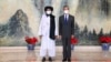 FILE - In this July 28, 2021, photo released by China's Xinhua News Agency, Taliban co-founder Mullah Abdul Ghani Baradar, left, and Chinese Foreign Minister Wang Yi pose for a photo during their meeting in Tianjin, China.