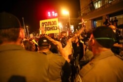 A demonstrator stands in front of a line of Israeli police officers during a protest against Israeli Prime Minister Benjamin Netanyahu in Jerusalem, July 18, 2020.