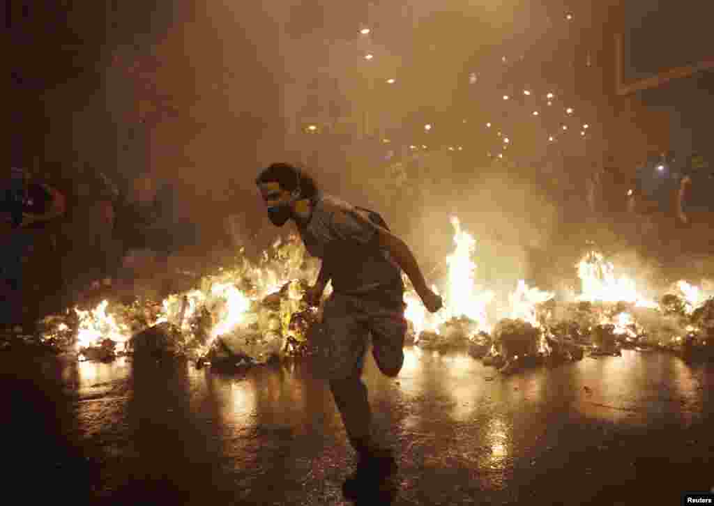 Seorang demonstran berjalan di luar Balai Kota selama protes mendukung pemogokan guru di Rio de Janeiro, Brazil.