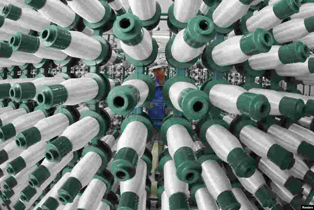 Seorang karyawan bekerja di sebuah pabrik tekstil di kota Jiujiang, provinsi Jiangxi, China.