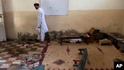 Seorang murid berjalan di sebuah kelas pasca ledakan di sekolah yang terletak di Karachi, Pakistan (28/4). Tiga siswa dilaporkan tewas dalam insiden tersebut.