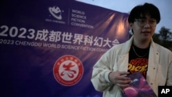 25岁的科幻迷陶博林(音译)在四川成都的世界科幻大会外手持《三体》的签名本。(2023年10月20日)