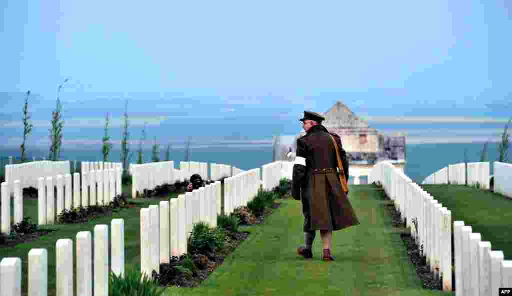 Seorang warga Australia mengenakan seragam Perang Dunia I, berjalan melewati kuburan para korban perang Australia selama PD I di kota Villers-Bretonneux, Perancis utara.
