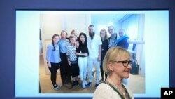 La ministre suédois des Affaires étrangères, Margot Wallstrom, sourit devant une photo de l'otage libéré Johan Gustafsson, au centre, et sa famille à l'aéroport d'Arlanda après son arrivée en Suède, à Stockholm, Suède, 26 juin 2017