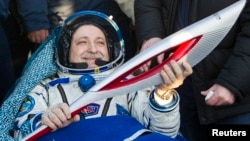 Russian cosmonaut Fyodor Yurchikhin holds the torch of the 2014 Sochi Winter Olympic Games after landing near the town of Zhezkazgan in central Kazakhstan, Nov. 11, 2013.