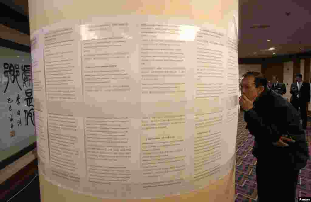 Kerabat penumpang China yang ada di pesawat Malaysia Airlines penerbangan MH370 yang hilang membaca pernyataan maskapai penerbangan itu di sebuah hotel di Beijing (18/3).