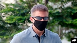 CORRECTS SOURCE - In this May 13, 2020, photo, Brian Dugan Yeargan, wearing a face mask and sunglasses, walks outside the Singapore State Court in Singapore. The 44-year-old American pilot has been jailed for four weeks for breaching a quarantine…