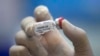 A lab technician holds a bottle containing results for a COVID-19 vaccine at a testing center run by Chulalongkorn University in Saraburi Province, north of Bangkok, Thailand, May 23, 2020.