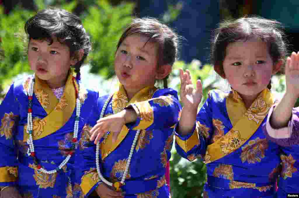 Anak-anak bernyanyi saat pemimpin Buddha Trinley Dorje ikut dalam upacara untuk memberkati Monumen Perdamaian di London, Inggris.