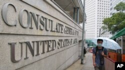 资料照片：中国2003年爆发非典疫情后，香港一位男子4月2日戴口罩行走在美国驻香港总领馆外面的人行道上。