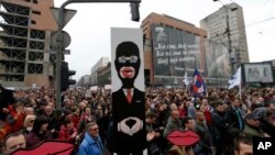 Demonstrant drži transparent sa likom premijera Aleksandra Vučića pod kapom "fantomkom" tokom "Protesta protiv diktature", u Beogradu, 8. aprila 2017. (AP Photo/Darko Vojinovic)