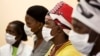 FILE - Patients with tuberculosis (TB) and HIV wear masks while awaiting consultation at a clinic in Cape Town's Khayelitsha township, South Africa.