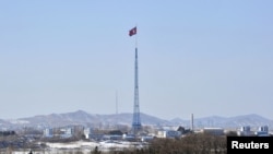 在边境村庄板门店附近飘扬的朝鲜国旗