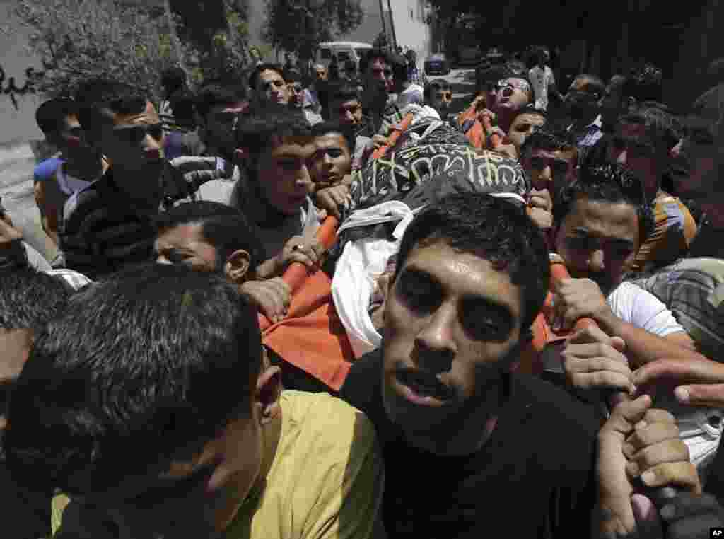 Palestinians carry the body of Islamic Jihad militant Mohammed Sowelim, who was killed in an Israeli air strike, during his funeral in Jabaliya refugee camp, in the northern Gaza Strip, July 12, 2014. 