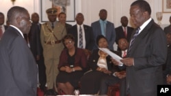 Emmerson Mnangagwa, right, is sworn in as vice president by Zimbabwean President Robert Mugabe at State House in Harare, Friday, Dec, 12, 2014. (AP Photo/Tsvangirayi Mukwazhi)