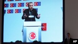 7일 터키 이스탄불에서 레제프 타이이프 에르도안 터키 총리가 연설을 하는 가운데 개인 경호원이 스크린 옆에 서서 지키고 있다. 