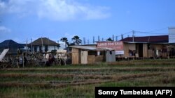 Papan bertuliskan "Tanah Dijual" terlihat di tengah hamparan sawah di Canggu, Kabupaten Badung, Bali, 22 Oktober 2024. (Foto: SONNY TUMBELAKA/AFP)