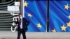 A man wearing a protective mask walks past the EU Commission headquarters amid the coronavirus outbreak, in Brussels, Belgium, Sept. 18, 2020. 