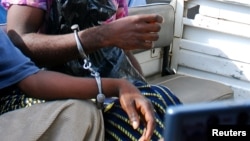 Des hommes menottés embarqués pour le tribunal de Blantyre, Malawi, 4 janvier 2010.