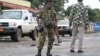 FILE - A Burundian soldier with his gun and rocket launcher guard a deserted street in Bujumbura, Burundi.