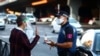 A local police officer speaks with a woman in the Vallecas neighborhood during the first day of a partial lockdown between and within areas in six districts amid the outbreak of the coronavirus disease (COVID-19) in Madrid, Spain, Sept. 21, 2020.