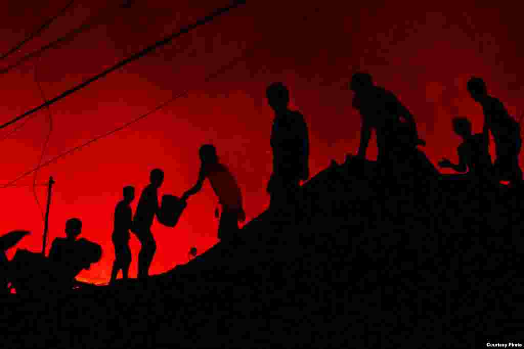 Atho Ullah dari Indonesia dengan fotonya berjudul &quot;The Fire Fighters&quot;, tentang warga Karang Anyar, Jakarta Pusat, yang bergotong royong memadamkan api.