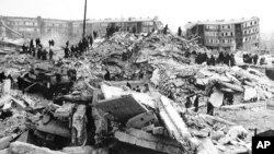 Teams of workers climb over rubble left by the earthquake. Leninakan, Armenia, Dec. 12, 1988. 