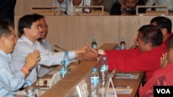 PM Abhisit Vejjajiva berjabat tangan dengan pemimpin demonstran Veera Musikapong dalam pertemuan di Bangkok, 28 Maret 2010.