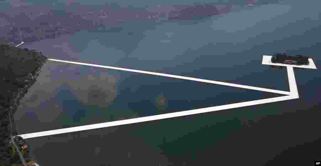 រូបភាព​ពី​អាកាស​បង្ហាញ​ពី​ពិព័រណ៌​ &laquo;The Floating Piers&raquo; ដោយ​សិល្បករ​ជនជាតិ​ប៊ុលហ្គារី​លោក Christo Vladimirov Yavachev ដែល​ត្រូវ​​បាន​ស្គាល់​តាម​ឈ្មោះ​ថា Christo នៅ​លើ​បឹង​ Iseo ភាគ​ខាង​ជើង​ប្រទេស​អ៊ីតាលី។&nbsp;