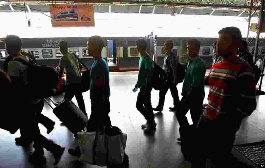 Men arrive at a train station in Bangalore to head north.