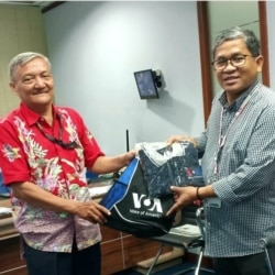 Heribertus Sunu Budiarjo (kiri) menerima cindera mata VOA dari Direktur Biro Jakarta, Agus Sunarto. (Foto: Sunu Budiarjo)