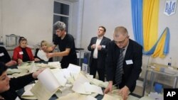 Komisi Pemilu Ukraina menghitung surat suara yang masuk di sebuah TPS di Kiev, Ukraina (28/10). 