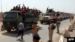 Kaum lelaki Irak yang secara sukarela bergabung melawan serangan kelompok jihadis di Irak utara naik truk tentara ketika mereka meninggalkan pusat perekrutan mereka di ibukota Baghdad, 13/6/2014.