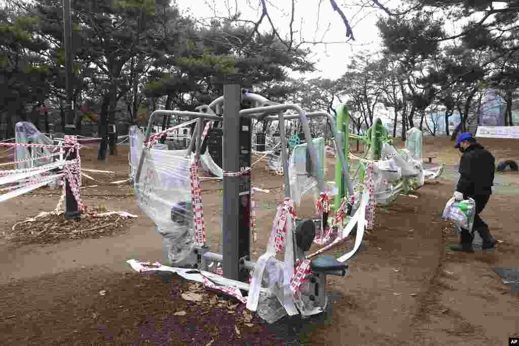 Peralatan olahraga di sebuah taman bermain ditutup dengan plastik, di tengah larangan penggunaan fasilitas olahraga umum karena pemberlakuan protokol kesehatan di tengah pandemi Covid-19 di Goyang, Korea Selatan. (Foto: AP)