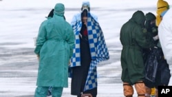 身穿防护服的俄罗斯医护人员在秋明附近的一个机场迎接俄罗斯军机从武汉撤回的侨民。（2020年2月5日）