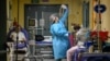 A medical worker is seen as patients suffering with the coronavirus disease are treated in the emergency room of the Maggiore di Lodi hospital, in Lodi, Italy, Nov. 13, 2020. 
