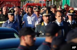 Interior Minister Matteo Salvini, center, arrives at the site where the Morandi highway bridge collapsed, in Genoa, northern Italy, Aug. 15, 2018.