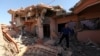 FILE - A Christian man inspects his neighbors' home, destroyed by Islamic State militants in the Christian city of Qaraqosh, Iraq, Sept. 12, 2018.