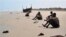 In this image released by UNHCR, unidentified refugees rest on an undisclosed beach in Yemen in March 2007. Many Ethiopians and Somalis hire smugglers to get them to Yemen. However, many are robbed, abused and some even thrown overboard. 