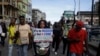 Des gens brandissent des banderoles alors qu'ils manifestent dans la rue pour protester contre la brutalité policière à Lagos, au Nigeria, le samedi 17 octobre 2020.