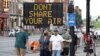 FILE - A sign encouraging the wearing of masks and keeping social distancing stands at a street corner in downtown Nashville, Tenn., Aug. 5, 2020.