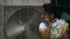 Hindistan'ın güneyindeki Telangana eyaletinde bir kadın, vantilatörün önünde serinlemeye çalışıyor. 