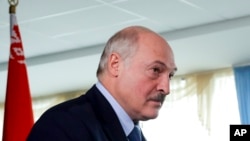 Le président biélorusse Alexandre Loukachenko marche après avoir voté dans un bureau de vote lors de l'élection présidentielle à Minsk, en Biélorussie, dimanche 9 août 2020.
