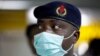 FILE - A Nigerian health official wearing a protective mask waits to screen passengers at the arrivals hall of Murtala Muhammed International Airport in Lagos, Nigeria.