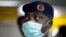 FILE - A Nigerian health official wearing a protective mask waits to screen passengers at the arrivals hall of Murtala Muhammed International Airport in Lagos, Nigeria.